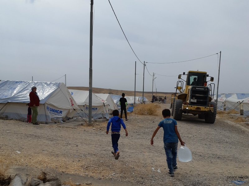 Children helping their family to carry water.