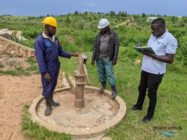 破損したハンドポンプ式井戸を調べるスタッフ① (1)